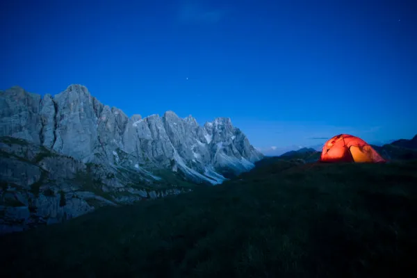 Fotografie montană: Munți, în față cort pe o pajiște.